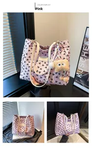 Détail du sac cabas matelassé rose avec nœuds noirs et breloque en peluche monstre