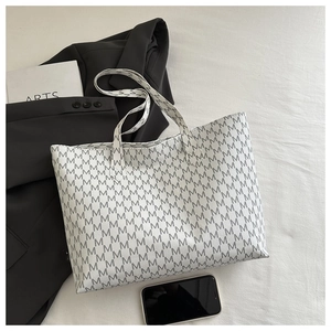 Flat lay of large white tote bag with grey M letter print and office accessories