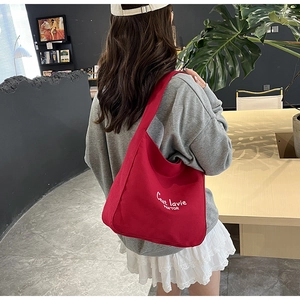 Detail of red canvas tote bag featuring white letter embroidery and French casual style