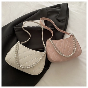 Détail de sacs bandoulière matelassés avec chaîne en perles en beige et rose