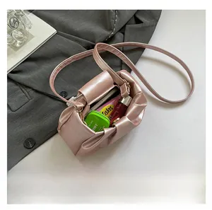 Pink pleated crossbody bag with pearl handle showing spacious interior and daily essentials