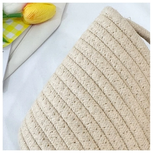 Detailed close-up of ivory woven cotton rope bag featuring reinforced zigzag stitching texture