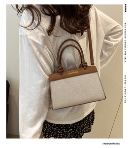 Detail of retro bi-color canvas and brown leather handbag with detachable shoulder strap
