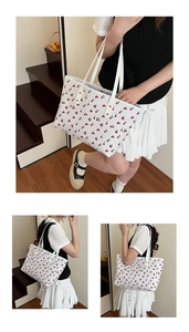 Detail of cute cherry print tote bag with golden rivets and high-quality leather texture