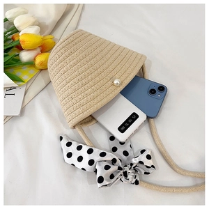 Interior space of beige straw bag showing storage for a phone and power bank
