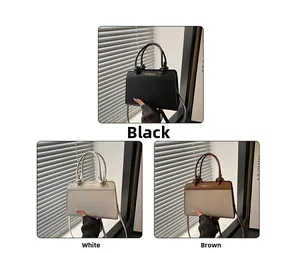 Close-up of stylish handbags in black, white, and brown with knotted handle details