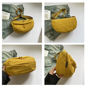 Detail view of yellow nylon crossbody bag featuring dual zippers and adjustable strap