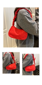 Détail du sac demi-lune en daim rouge avec bandoulière froncée style scrunchie