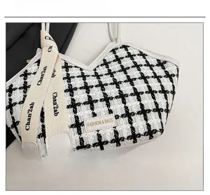 Détail d'un cabas à carreaux avec tissu tissé et décoration de sangle à logo élégante