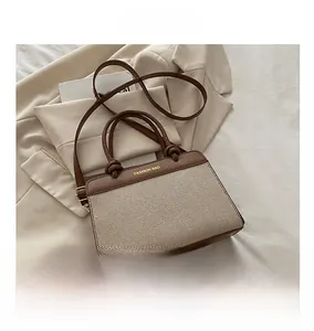 Detail of color-block leather crossbody bag on a blazer with mobile phone for size comparison
