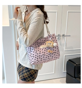 Détail du sac cabas rose avec motifs nœuds, texture gaufrée et charm en peluche