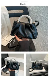Detail of black pleated cloud bag with pearl handle and detachable leather strap