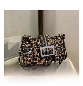 Macro detail of leopard print shoulder bag with silver rivets and metallic buckle strap