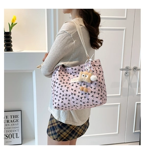 Détail d'un cabas rose matelassé avec motifs de nœuds et charm pendentif hibou en peluche