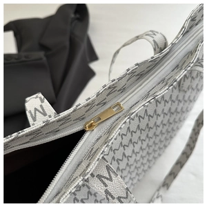 Detail of the high-quality gold zipper and monogram pattern on the white tote bag