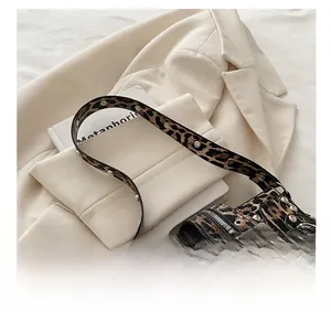 Detail of leopard print crossbody bag with silver studs and large metal buckle