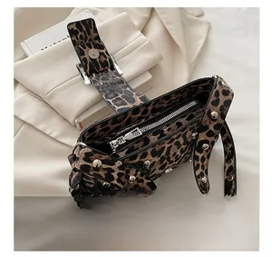 Macro view of smooth silver zipper and punk rivets on leopard print handbag