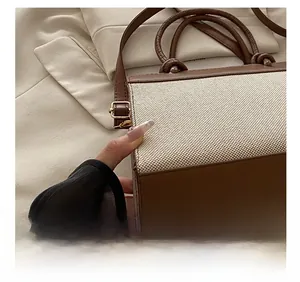 Detail shot of brown leather and beige canvas stitching on the crossbody bag