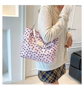 Détails du sac cabas rose avec motifs de nœuds noirs et texture en relief
