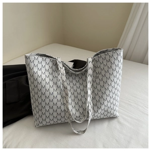 Detail of white tote bag with repetitive grey letter M print on high-quality fabric