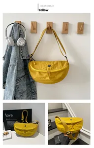 Detail of yellow nylon crescent crossbody bag with adjustable strap and OK badge