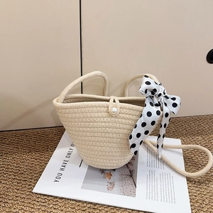 Chic beige woven straw handbag with pearl buckle and polka dot silk scarf detail
