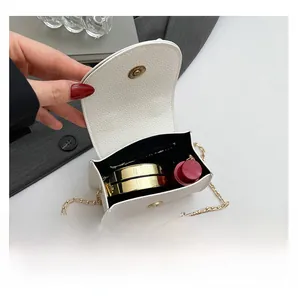 Nahaufnahme einer weißen Umhängetasche aus Leder mit Platz für Lippenstift im Inneren