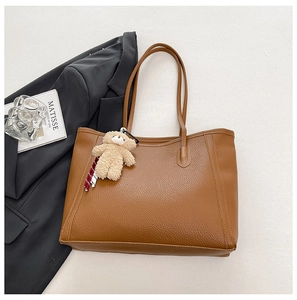 Détail du sac cabas en cuir marron à texture litchi avec pendentif ours peluche