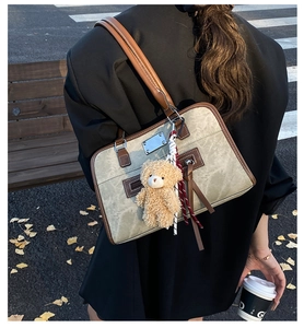 Gros plan du sac fourre-tout vintage en toile avec anses en cuir et charme d'ours en peluche