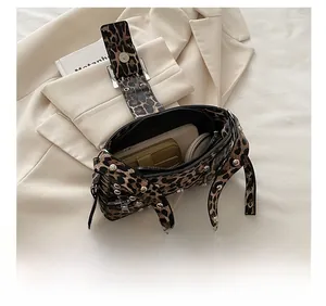 Internal view showing capacity of leopard print shoulder bag with silver studs and accessories