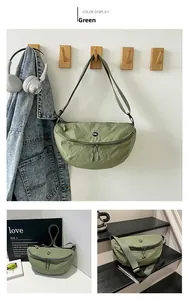 Detail view of grass green nylon crescent bag with OK logo and adjustable shoulder strap