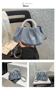 Detail of light blue cloud pleated bag with pearl handle and slim shoulder strap