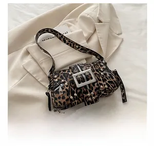 Nahaufnahme der Schultertasche mit Leopardenmuster, Nieten und Handy zum Größenvergleich