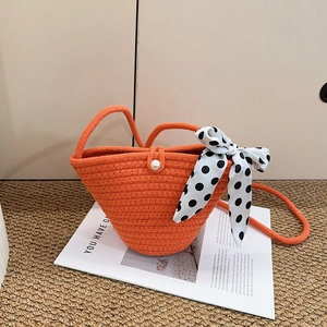 Vibrant orange woven handbag with pearl clasp and black-white polka dot silk scarf