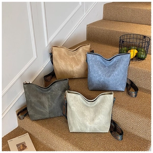 Four vintage hobo bags in assorted colors displayed on stairs with ethnic wide straps