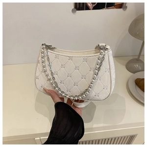 Détail du sac sous le bras matelassé blanc avec broderie nœud et chaîne en perles
