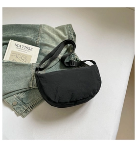 Detail of the black nylon crescent bag with adjustable strap and textured fabric