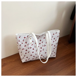 Detail of cute cherry print canvas tote bag with reinforced metal rivets and white straps