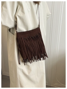 Close-up of deep brown suede crossbody bag featuring dense long fringe decoration