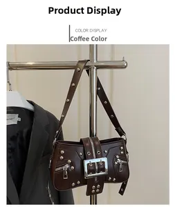 Close-up of brown punk shoulder bag featuring silver rivets and large buckle detailing