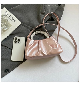 Detail of metallic pearl pink cloud bag with pearl handle and leather shoulder strap