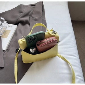 Interior capacity detail showing yellow mini bag holding a phone and a small wallet