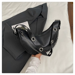 Detail of black crescent hobo bag with large silver grommets and chain strap decoration