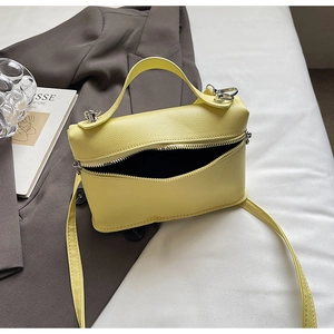 Detail of yellow lychee pattern leather handbag with silver hardware and top handle