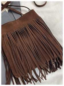 Gros plan détaillé d'un sac seau en daim marron avec franges au style bohème chic