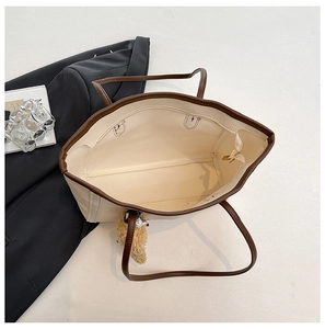 Top view of spacious tote bag with plush bear charm, brown leather trim and inner zip pocket