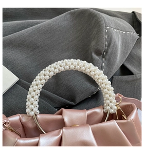 Detailed close-up of pink cloud bag featuring pleated texture and pearl handle