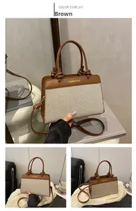 Detail of canvas tote bag with brown leather trim and knotted handle design