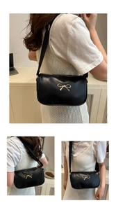 Close-up of golden bow clasp and smooth black faux leather texture on the bag