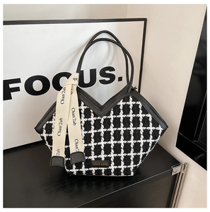 Détail de l'ouverture en V d'un sac cabas à carreaux noir et blanc avec ruban tendance